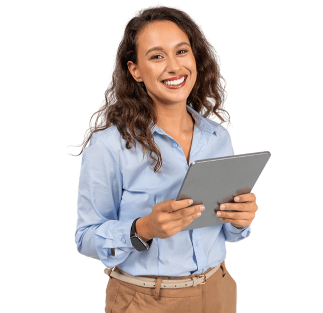 A woman with long curly hair, wearing a light blue shirt and tan pants, is smiling and holding a tablet.